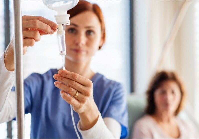 Doctor issuing IV fluids into needle