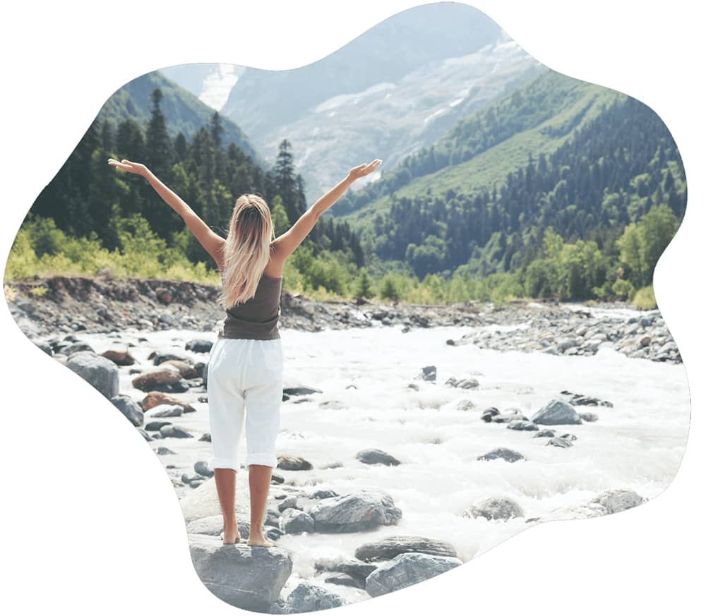 Woman in nature spreading her arms out